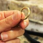 יד מחזיקה טבעת מוזהבת במהלך ייצור
